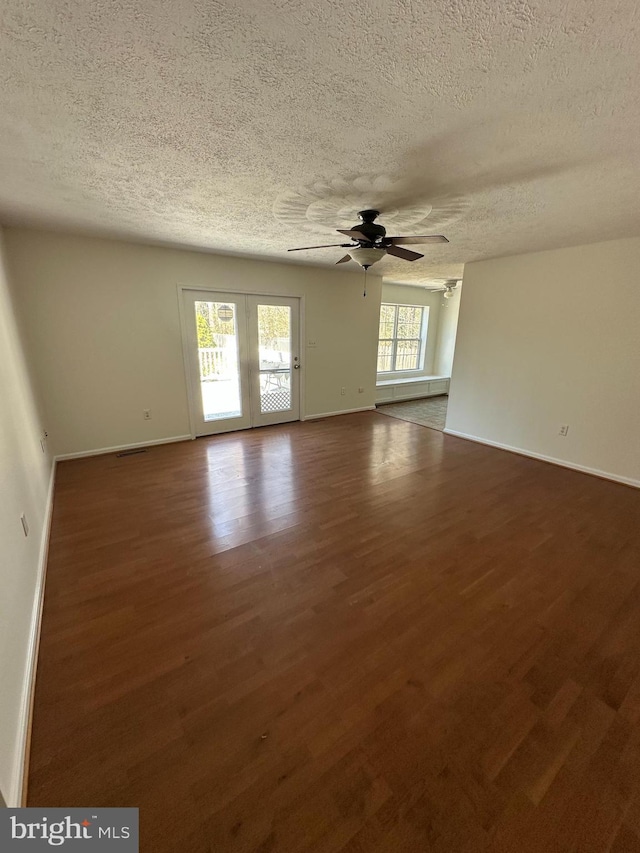 spare room with baseboards, wood finished floors, and a ceiling fan