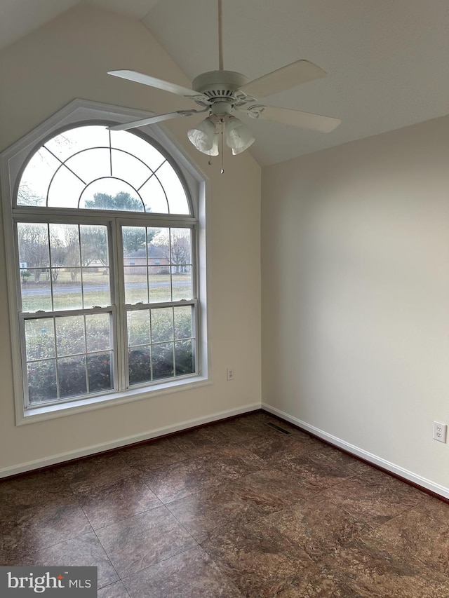 empty room with visible vents, ceiling fan, baseboards, and vaulted ceiling