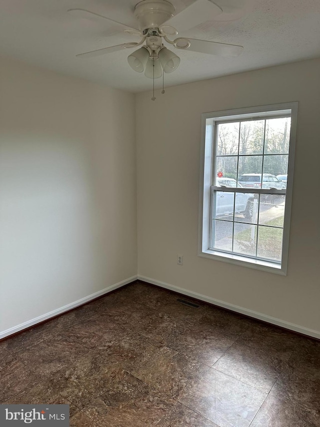 spare room featuring visible vents, baseboards, and ceiling fan