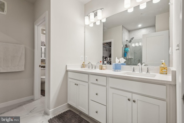 full bathroom with toilet, a stall shower, marble finish floor, and a sink