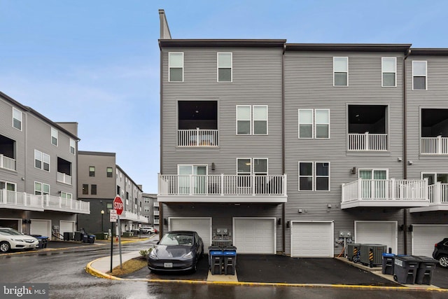 view of front of home featuring a garage, central air condition unit, and driveway