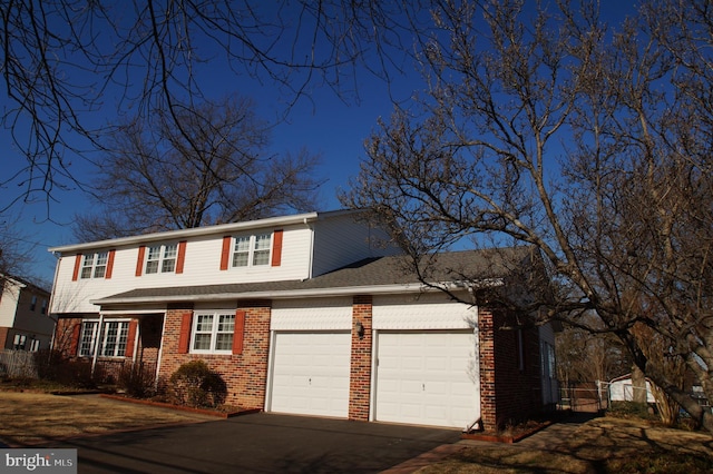 traditional-style home featuring a garage, brick siding, and driveway