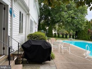 outdoor pool featuring a patio and area for grilling