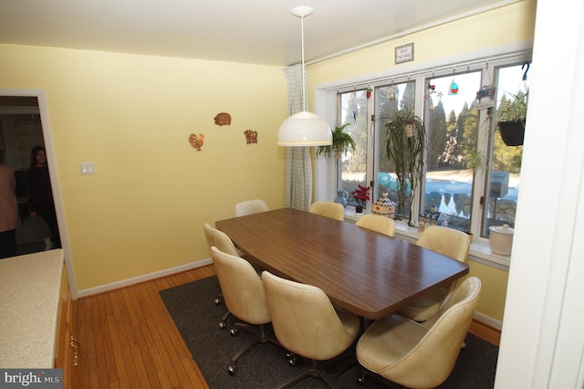 dining room with light wood-type flooring and baseboards