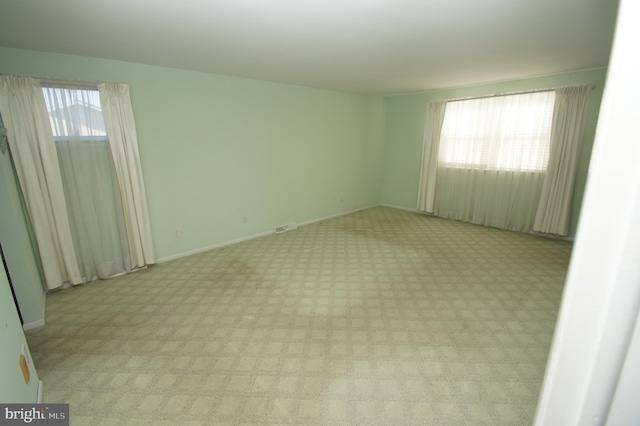 unfurnished room with visible vents and baseboards