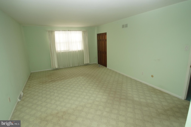 unfurnished room featuring visible vents and baseboards