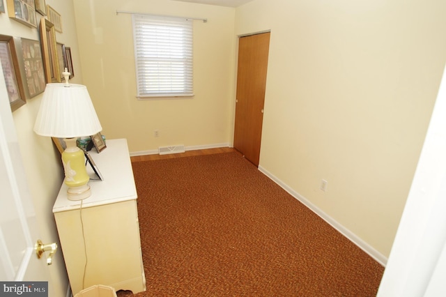 corridor featuring visible vents, baseboards, and carpet floors