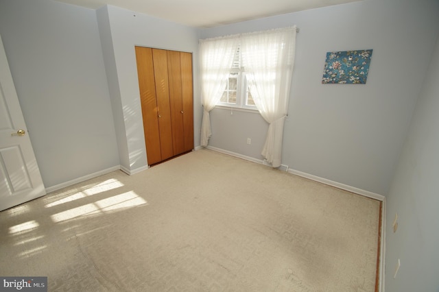 unfurnished bedroom featuring a closet, baseboards, and carpet