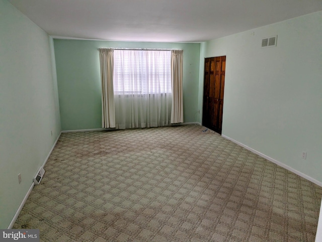 unfurnished room with visible vents and baseboards