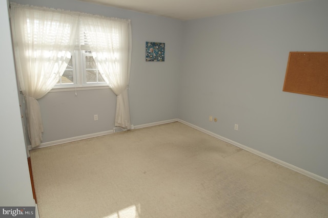 carpeted spare room with visible vents and baseboards