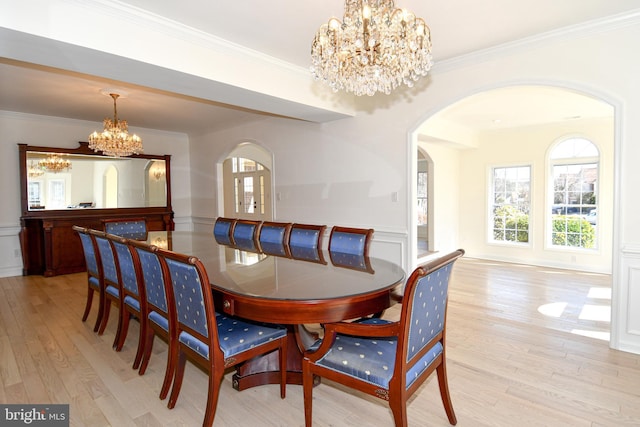 dining area featuring light wood finished floors, a chandelier, and crown molding