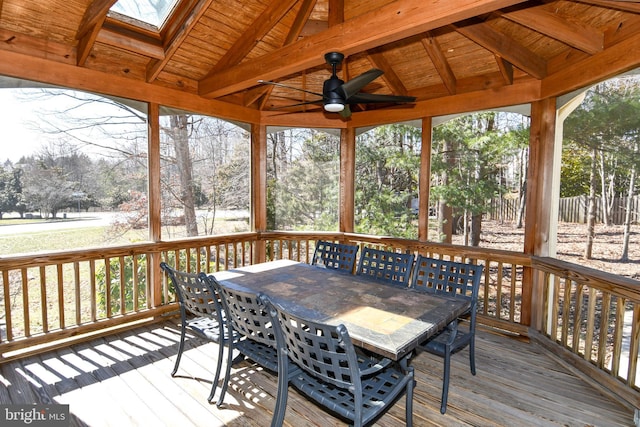 wooden terrace with outdoor dining space and a ceiling fan