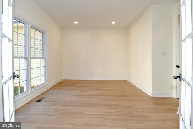 unfurnished room featuring light wood-style floors, baseboards, visible vents, and recessed lighting