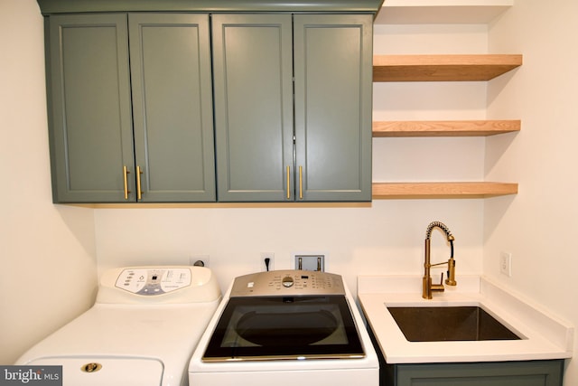 washroom featuring a sink, cabinet space, and washer and dryer