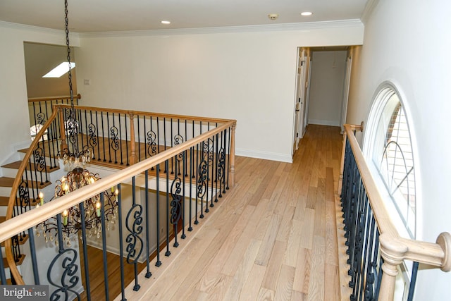 corridor featuring baseboards, ornamental molding, an upstairs landing, light wood-type flooring, and recessed lighting