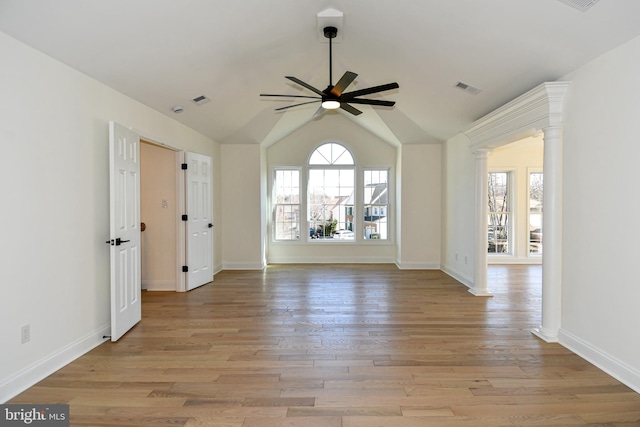 unfurnished room featuring decorative columns, visible vents, vaulted ceiling, ceiling fan, and light wood-type flooring