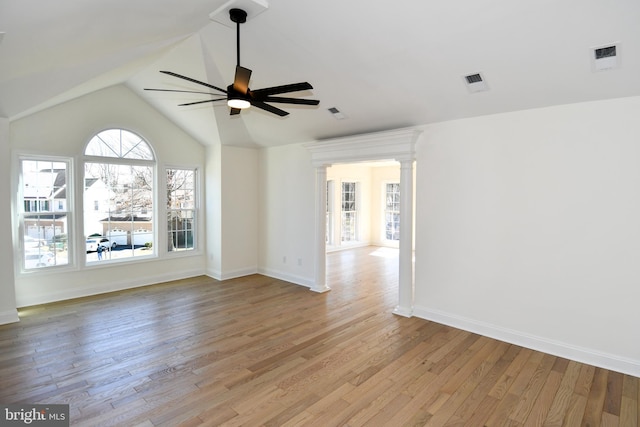 spare room with ceiling fan, lofted ceiling, visible vents, baseboards, and light wood-style floors