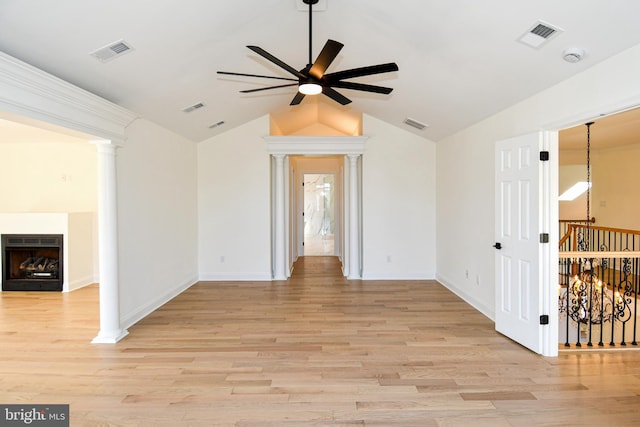 unfurnished room featuring light wood-style floors, decorative columns, a fireplace, and visible vents