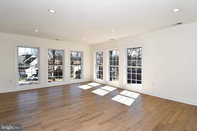 interior space featuring baseboards, wood finished floors, visible vents, and recessed lighting