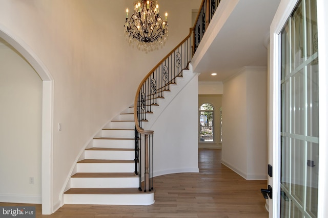 foyer featuring recessed lighting, wood finished floors, baseboards, ornamental molding, and stairway