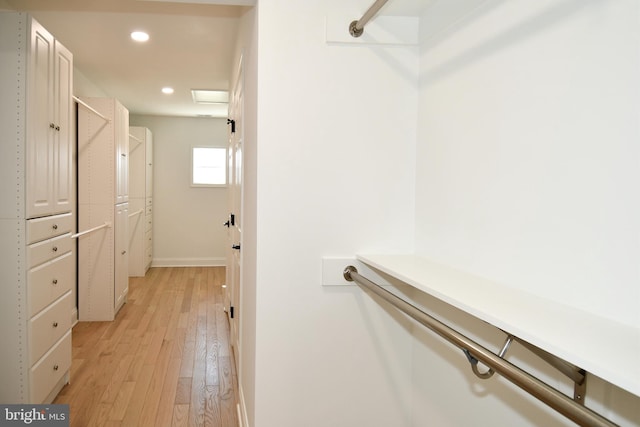 walk in closet with light wood-style floors