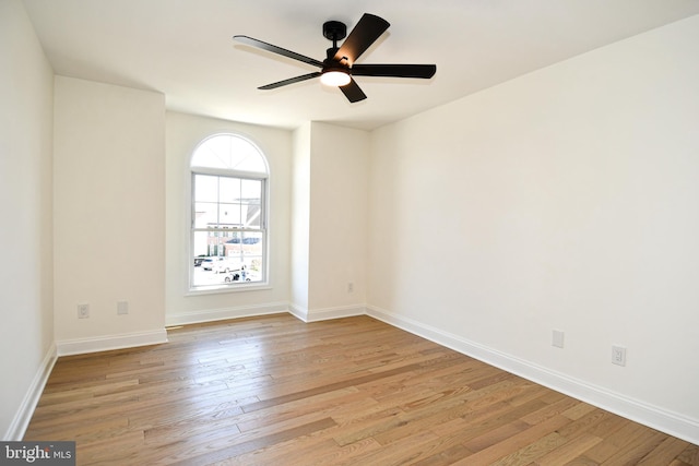 unfurnished room featuring baseboards, ceiling fan, and light wood-style floors