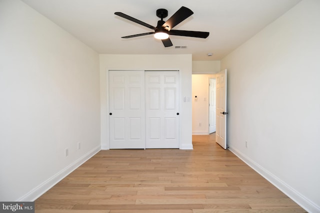 unfurnished bedroom with light wood-type flooring, a closet, visible vents, and baseboards