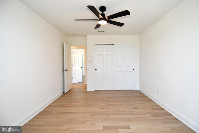 unfurnished bedroom featuring visible vents, baseboards, a ceiling fan, light wood-style flooring, and a closet