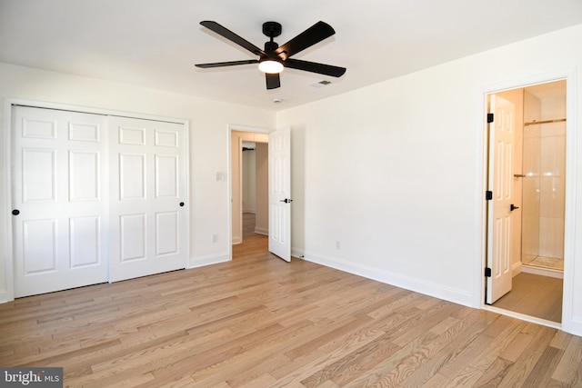 unfurnished bedroom with a closet, light wood-style floors, connected bathroom, ceiling fan, and baseboards