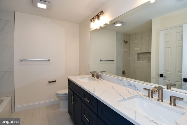 bathroom with baseboards, tiled shower, a sink, and toilet