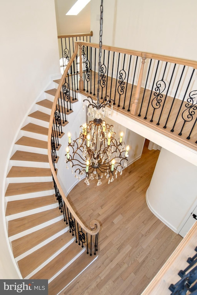 stairs featuring a skylight and wood finished floors