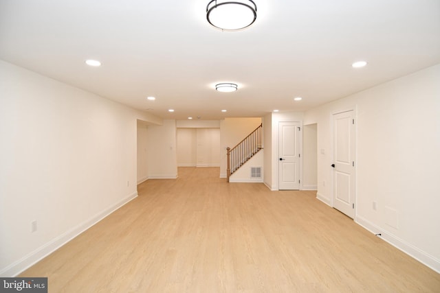 finished basement with light wood finished floors, recessed lighting, visible vents, baseboards, and stairs