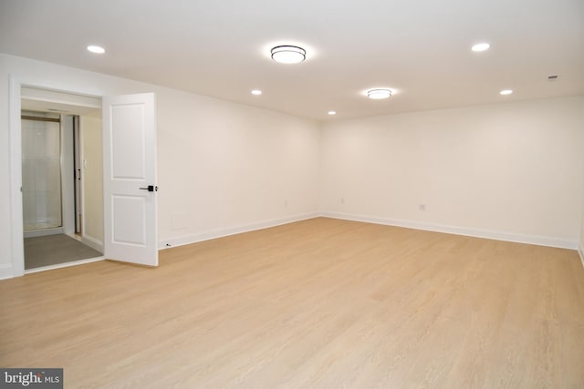 basement with baseboards, light wood-type flooring, and recessed lighting