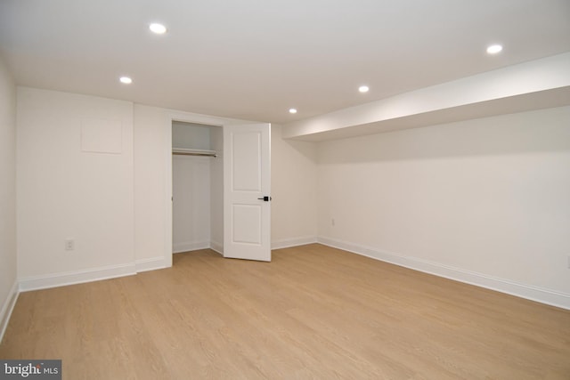 unfurnished bedroom with baseboards, a closet, light wood-style flooring, and recessed lighting