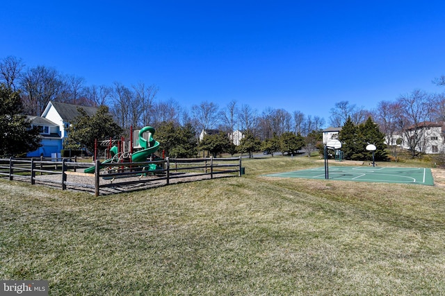 community play area with community basketball court, a lawn, and fence