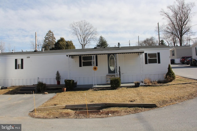 manufactured / mobile home featuring driveway and a porch