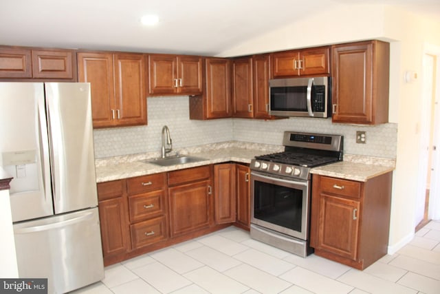 kitchen featuring stainless steel appliances, brown cabinets, a sink, and decorative backsplash