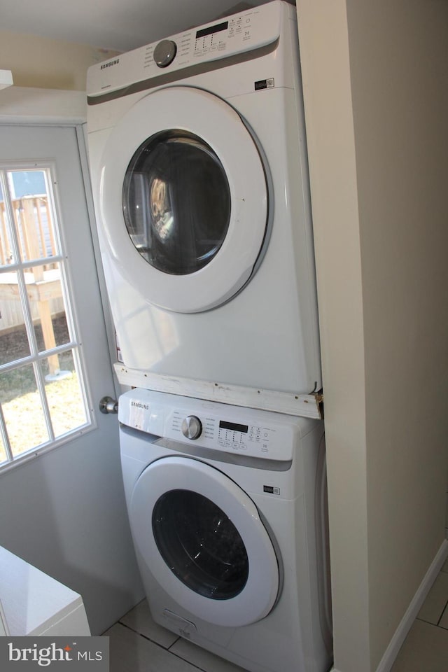 laundry room with stacked washer and dryer and tile patterned floors