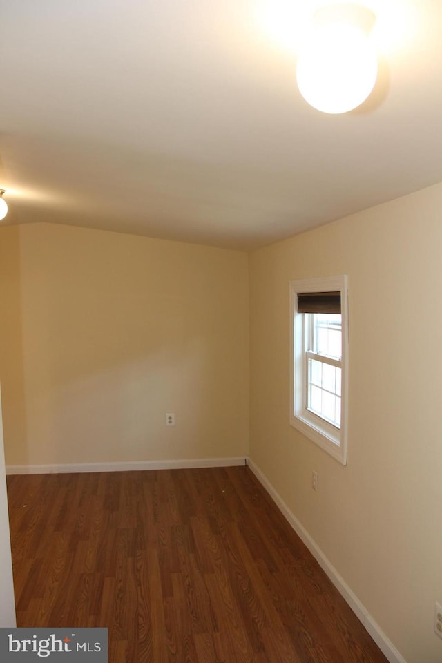 unfurnished room with dark wood-style floors and baseboards