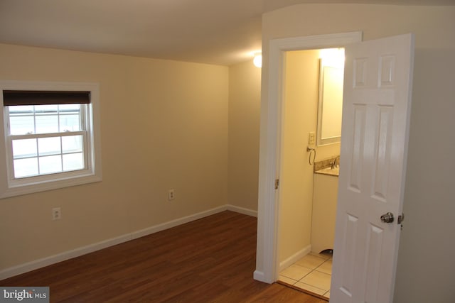 unfurnished bedroom featuring wood finished floors and baseboards