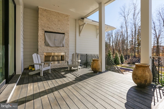 deck with an outdoor stone fireplace