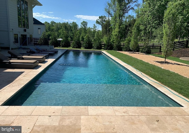 outdoor pool with a patio area and fence