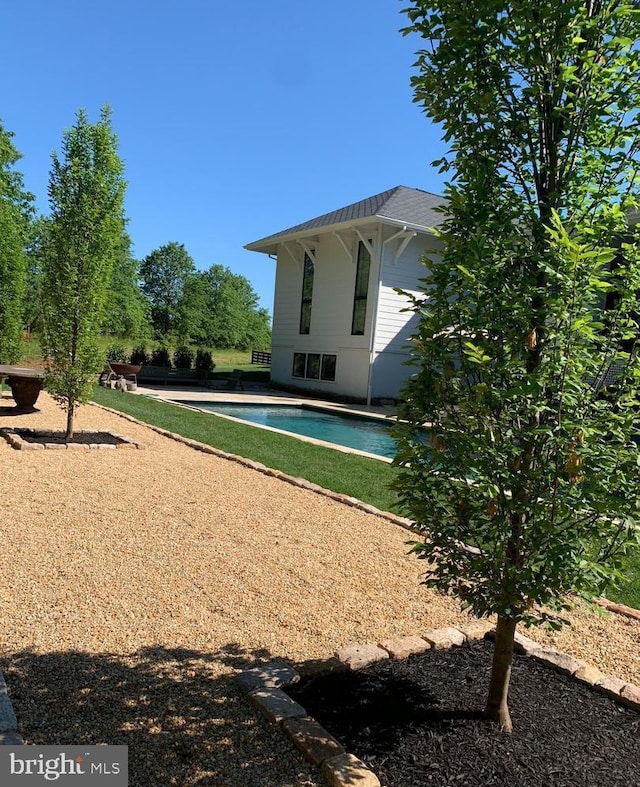 rear view of property with an outbuilding, a patio area, and an outdoor pool