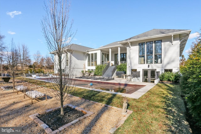 back of property with a yard, stairway, a patio, and french doors