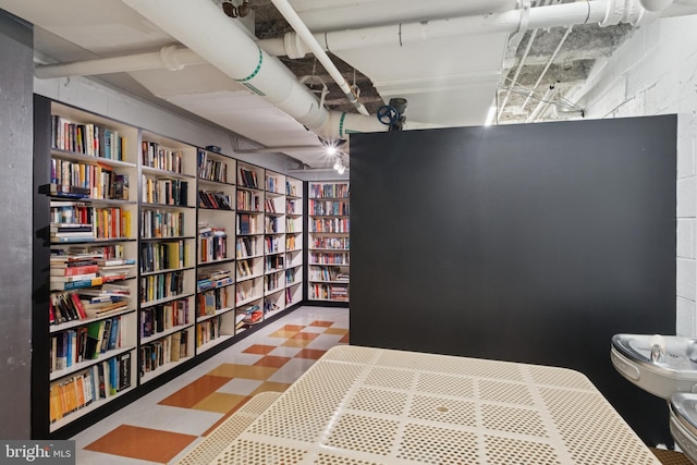 bedroom featuring concrete block wall and tile patterned floors