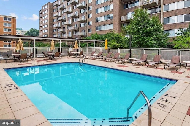 view of swimming pool with a patio area and fence