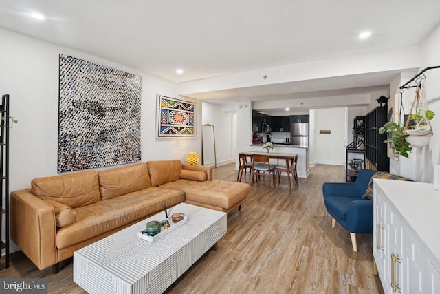 living area featuring baseboards, light wood-style flooring, and recessed lighting