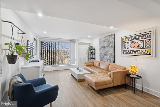 living room with baseboards, light wood-type flooring, visible vents, and recessed lighting