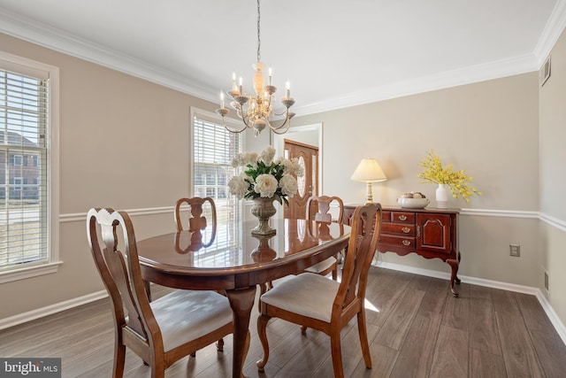 dining space featuring baseboards, a notable chandelier, wood finished floors, and ornamental molding