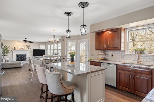 kitchen featuring a sink, a center island, a breakfast bar area, decorative backsplash, and dishwasher